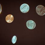 silver round coins on white surface — Foto por Chris Briggs na Unsplash